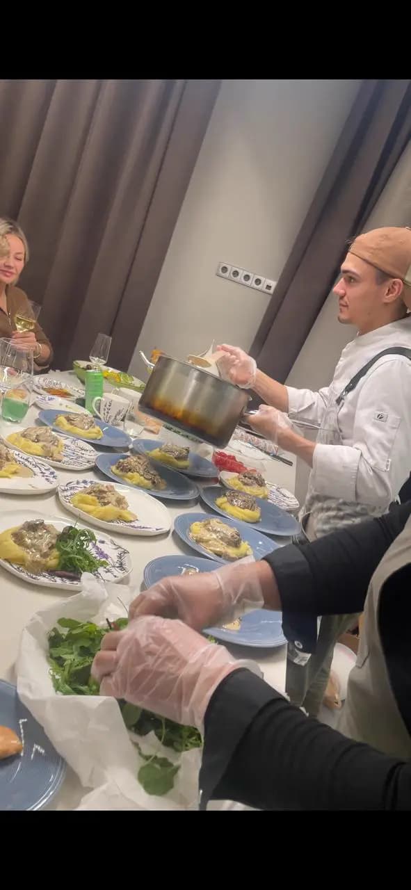 Повар раскладывает горячее
